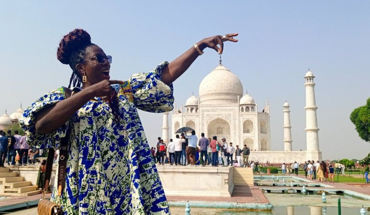 Tourist posing creatively in front of the Taj Mahal during daytime in Agra